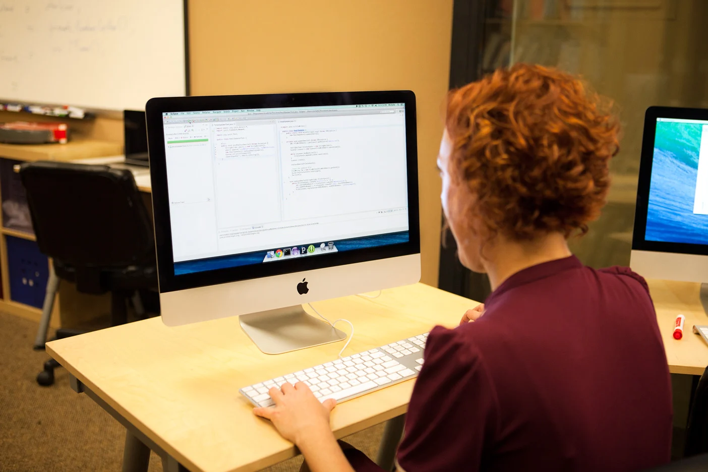Developer writing Java code with JUnit tests on a desktop computer in a 2014 photograph.