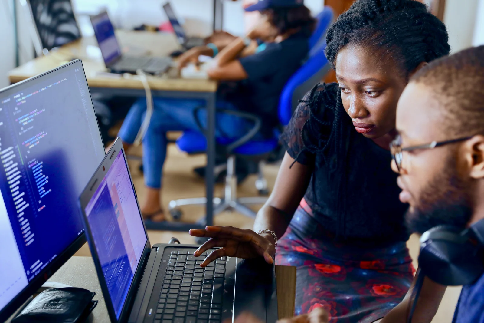 Two developers reviewing code together at a workstation in a 2022 photograph.